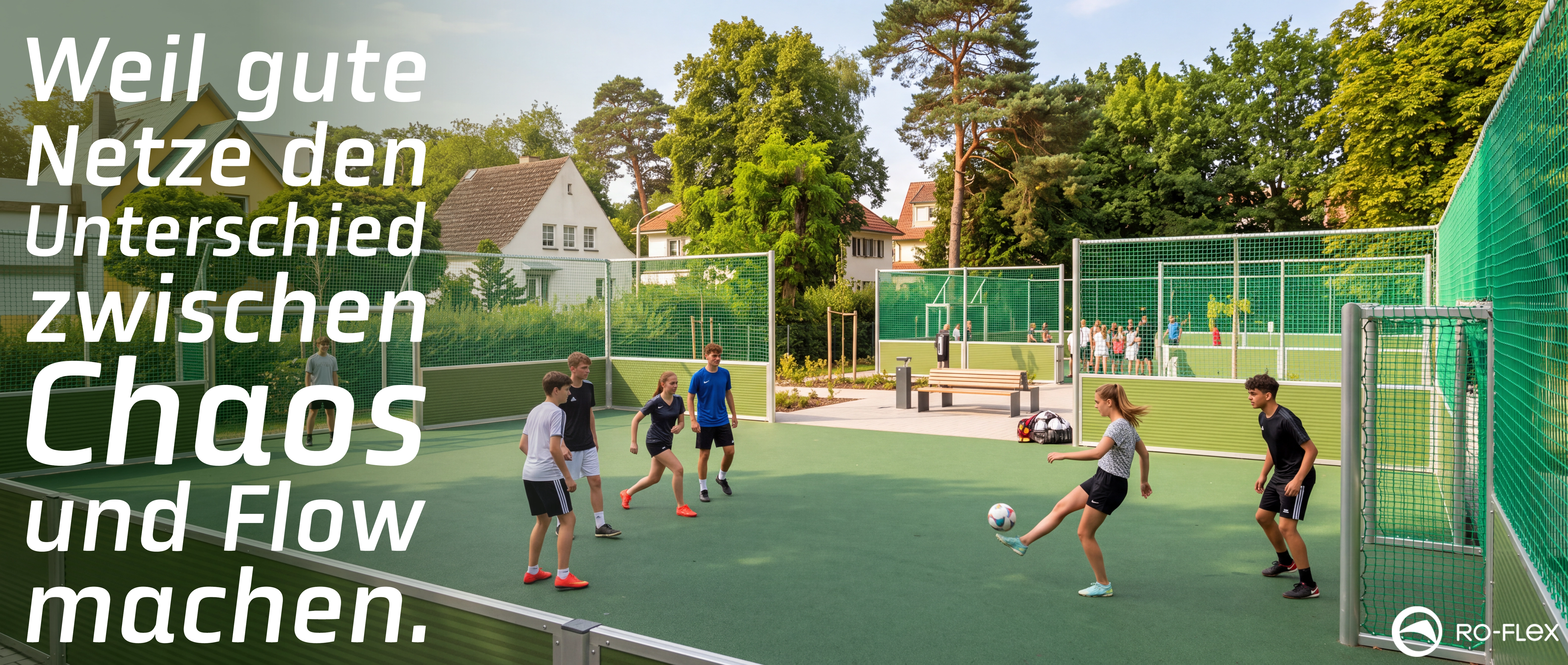 Moderner Sportplatz mit grünem Kunstrasen, auf dem Jugendliche Fußball spielen. Umgeben von hohen grünen Sicherheitsnetzen und Zäunen. Im Hintergrund Wohnhäuser und Bäume bei sonnigem Wetter. Logo von RO-FLEX unten rechts.