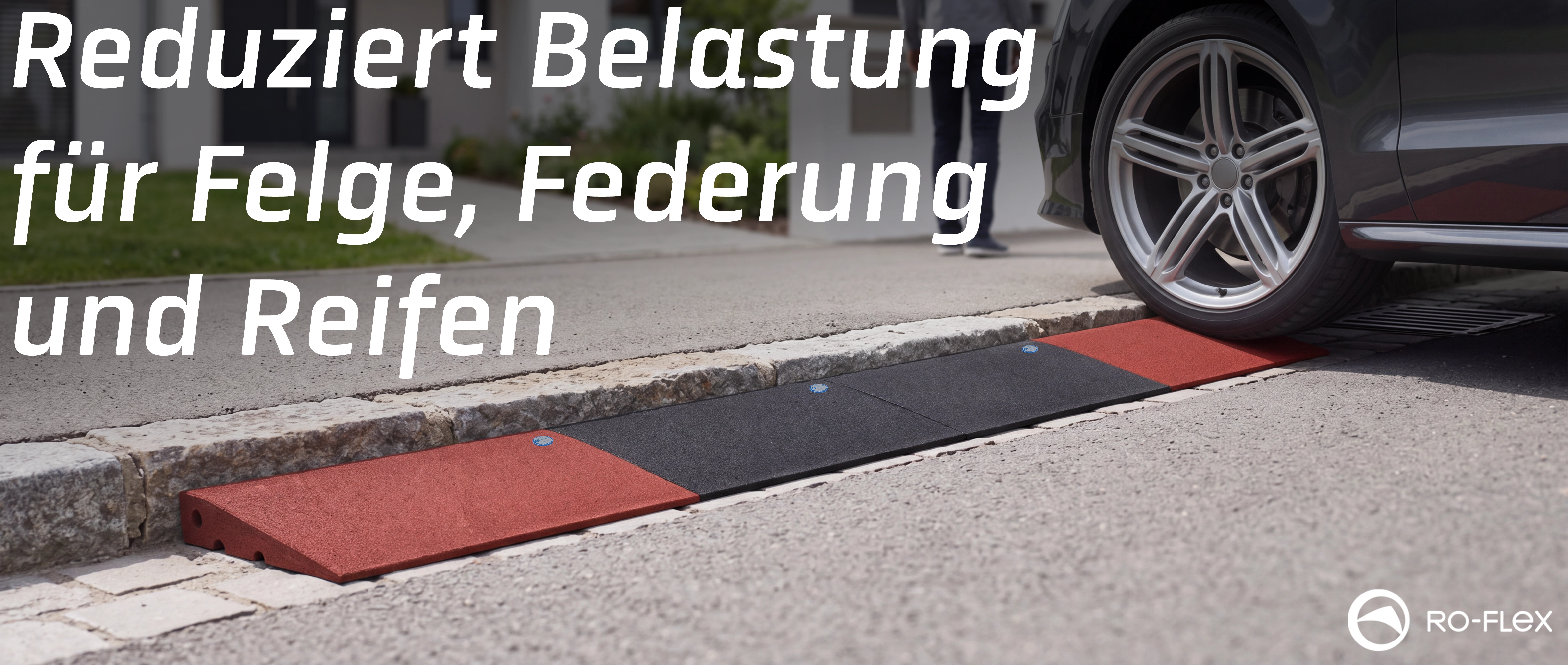 Schwarze und rote Gummi-Bordsteinrampe an einer Einfahrt, über die ein Autoreifen fährt. Die Rampe schützt Felgen, Federung und Reifen. Im Hintergrund ein Fußgänger und moderne Wohnbebauung. RO-FLEX-Logo unten rechts.