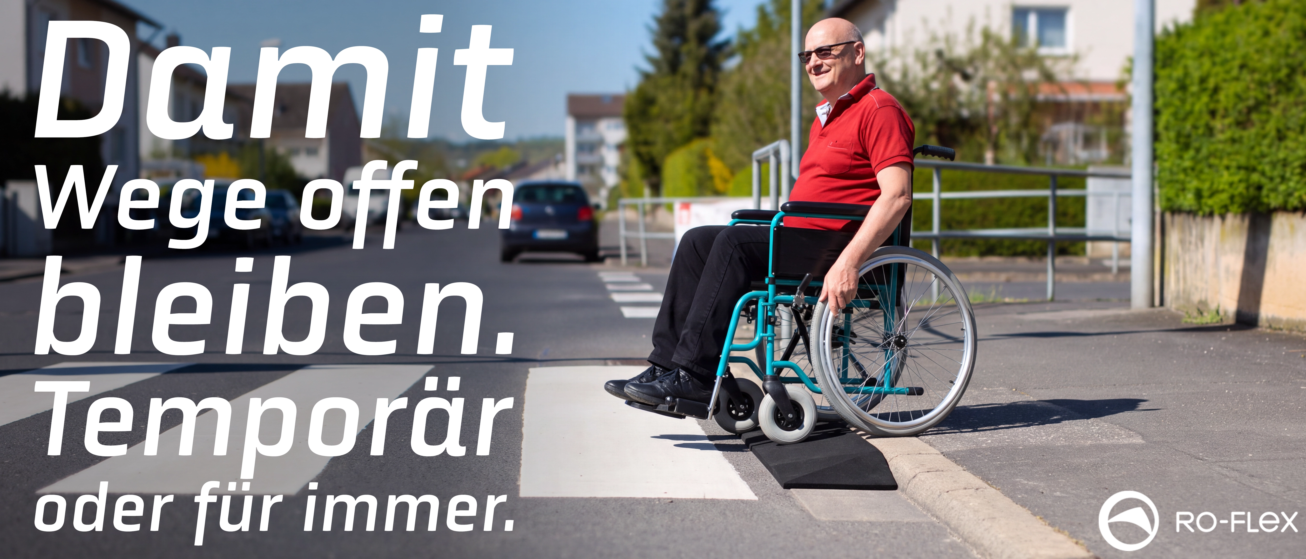Lächelnder Mann im Rollstuhl nutzt eine schwarze mobile Rampe, um einen Bordstein an einem Zebrastreifen zu überqueren. Sonnige Wohnstraße im Hintergrund. RO-FLEX-Logo unten rechts.