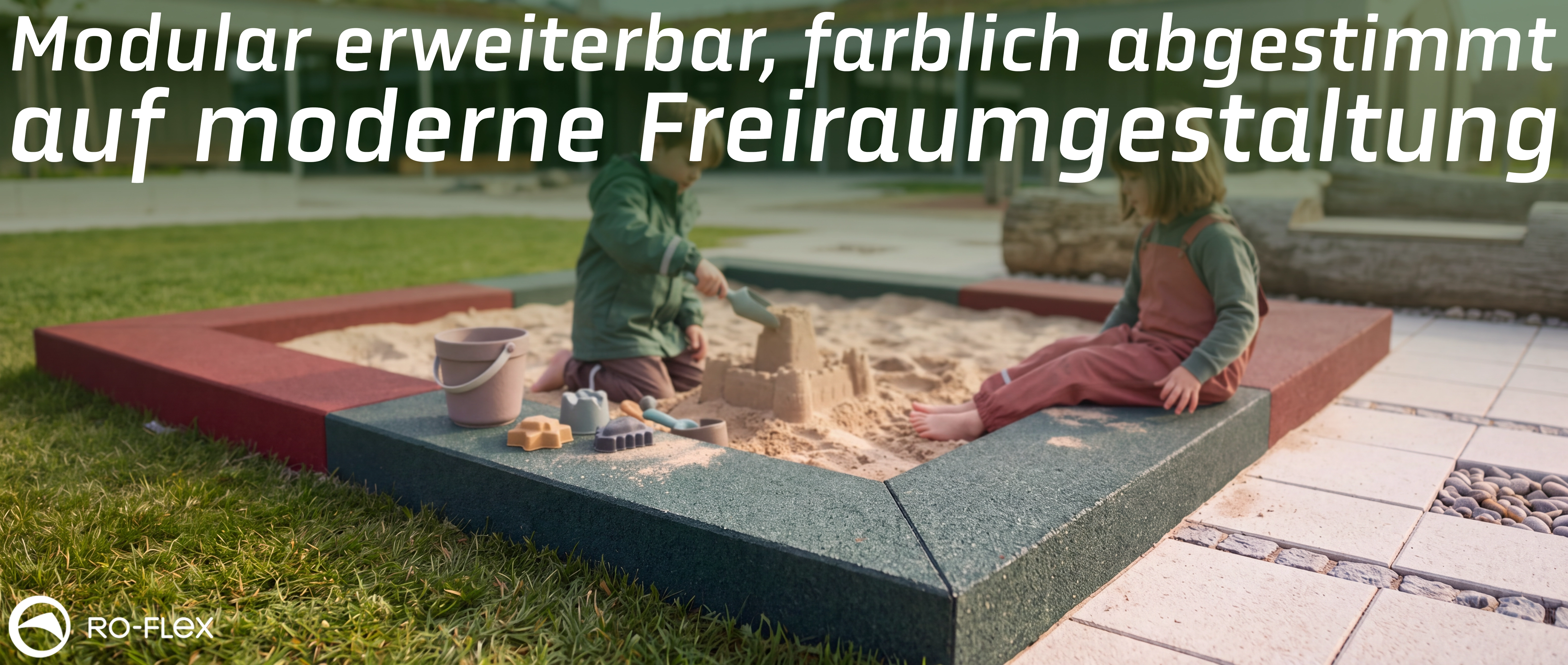 Moderner, modularer Sandkasten mit abgerundeter Umrandung in Grau und Rot. Zwei Kinder spielen darin mit Sandspielzeug und bauen eine Sandburg. Der Sandkasten steht auf einer Rasenfläche neben gepflastertem Weg vor einem modernen Gebäude. RO-FLEX-Logo unt